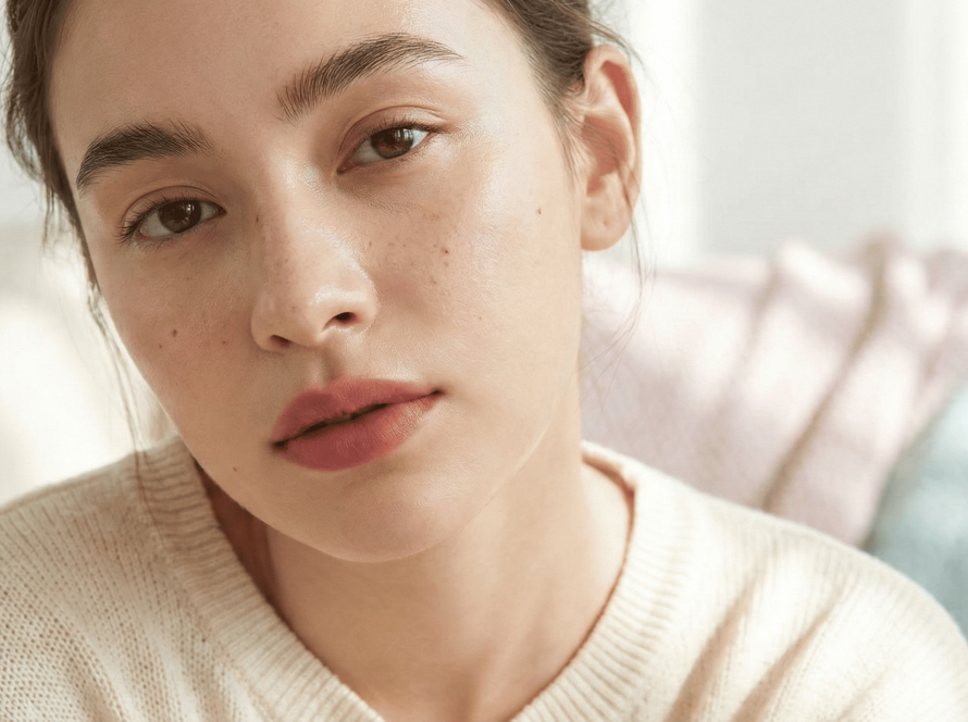 Blurred natural makeup look with soft lips, natural brows, and glowing skin, showcasing the no-makeup makeup beauty trend